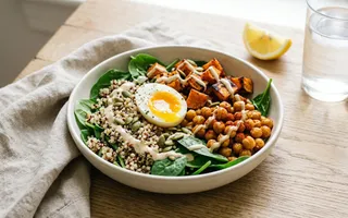 Bol de quinoa con espinacas, boniato asado, garbanzos crujientes, huevo y aliño de tahini